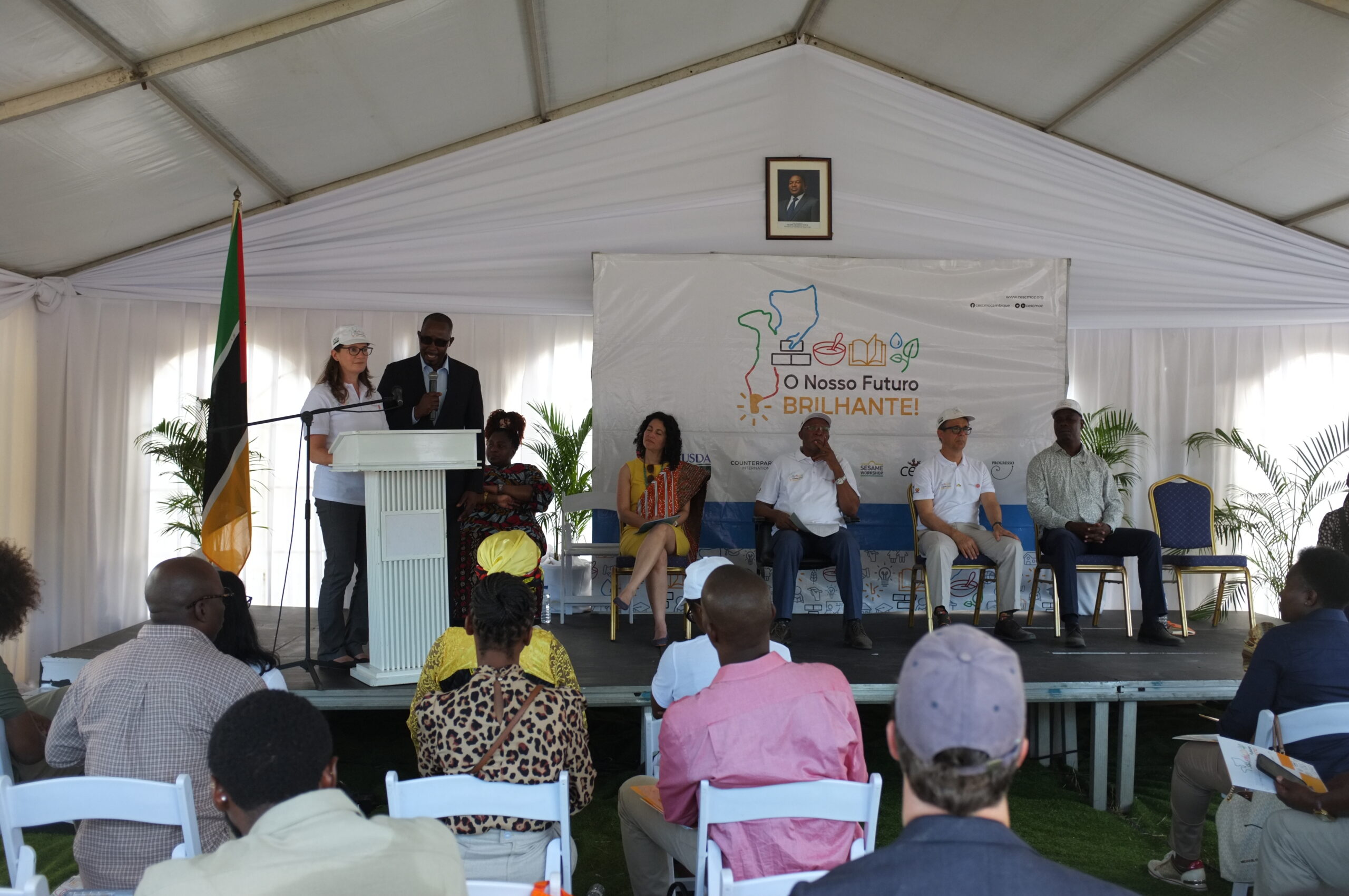 Gwen Appel, Counterpart's visc president of programs, addresses crowd at the event, standing beside the Deputy Security, Ambassador, and local government champions of school feeding.