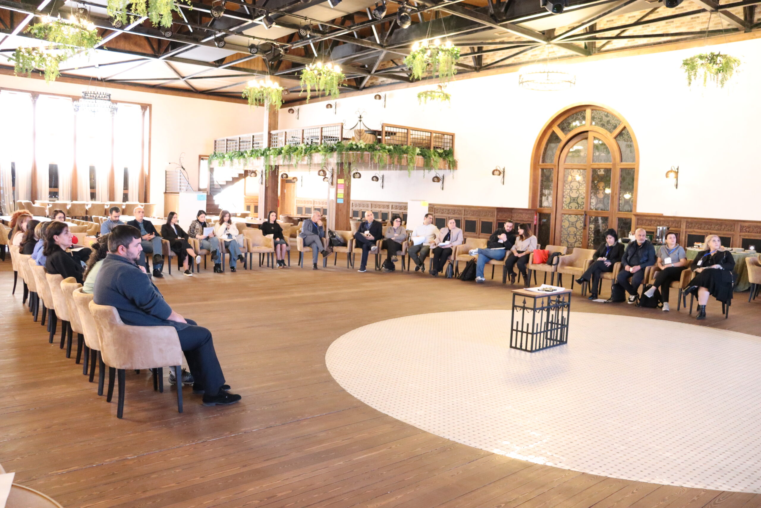 Participants sitting in a circle in a large conference room ready to start the Open Space event
